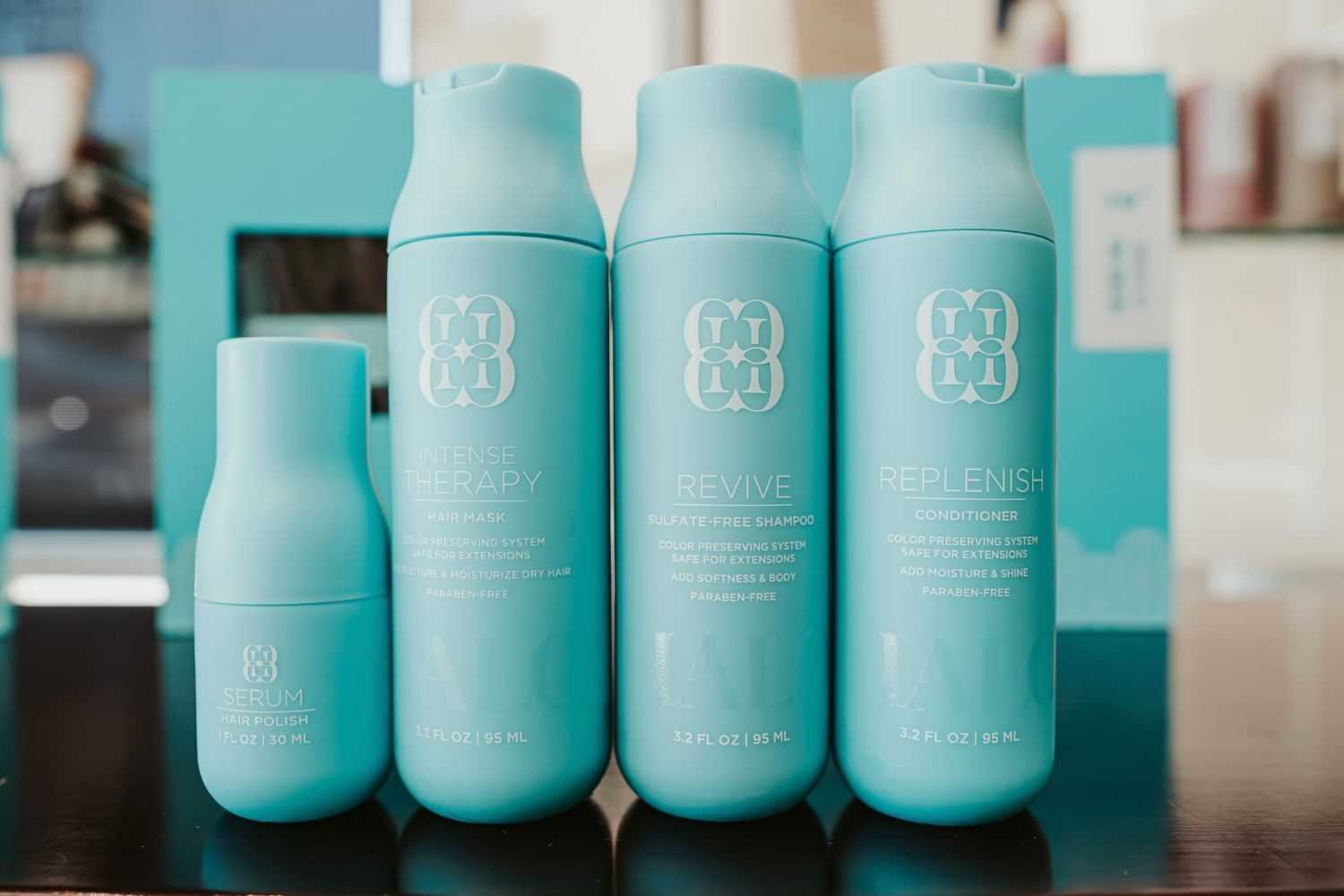 Blue hair care products lineup on a reflective surface.